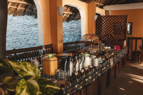 a long table in a restaurant with a lot of food at Blue Oyster Hotel in Jambiani