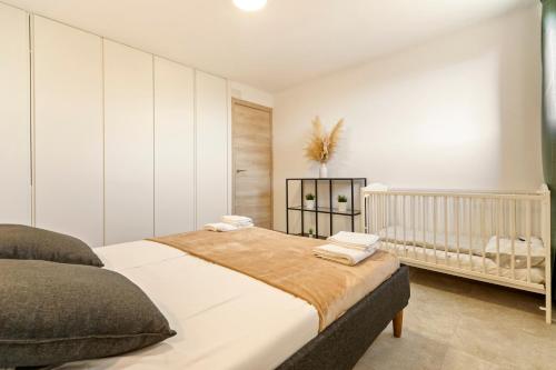 a bedroom with a large bed and a crib at Apartamento cerca de la playa in Barcelona