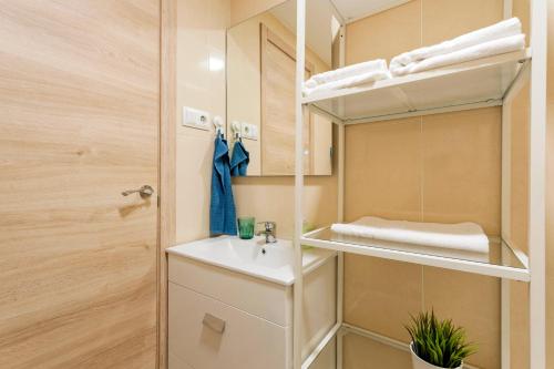 uma pequena casa de banho com um lavatório e um espelho em Apartamento cerca de la playa em Barcelona