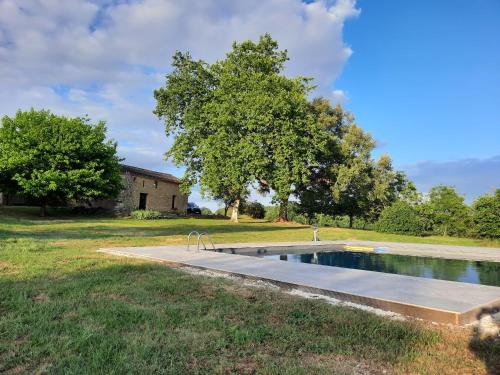 a swimming pool in a yard next to a house at Domaine de la Borie Blanche- Pomport Monbazillac - Gîtes 1ch, 2ch et 3ch in Pomport