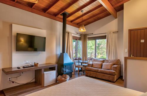 uma sala de estar com lareira e sofá em Hotel Canto Verde em Gramado
