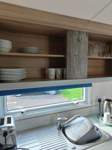 a kitchen counter with a sink and a window at Haven Holiday Park 3 bedroom Cala Gran Fleetwood in Thornton