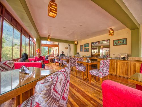 a restaurant with red chairs and tables and windows at Sol Ollantay Boutique Hotel in Ollantaytambo