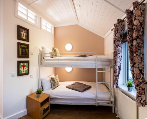 a bedroom with bunk beds in a attic at Montana Log Cabin - Ockeridge Rural Retreats in Wichenford