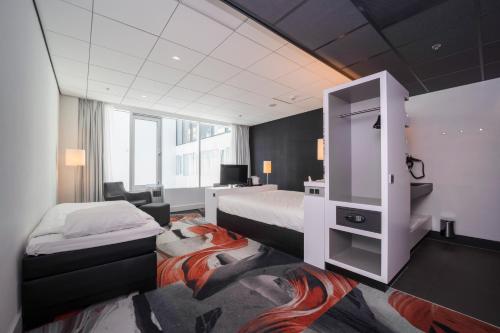 una camera d'albergo con due letti e un armadio di Fletcher Wellness-Hotel Leiden a Leida