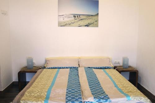 uma cama num quarto com uma fotografia na parede em Tarifa-Blick auf Afrika, Haus am Meer, Haustiere erlaubt em Tarifa