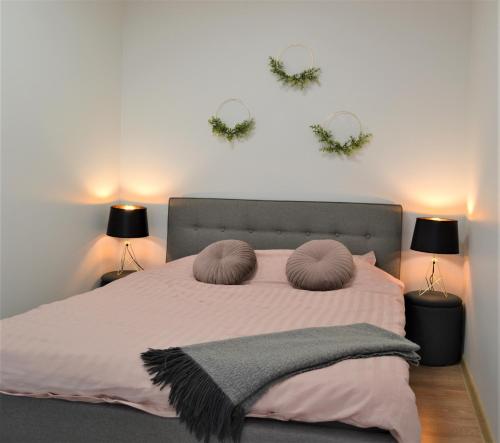 a bedroom with a bed with two mirrors on the wall at Aida 5 City Center Apartment in Pärnu