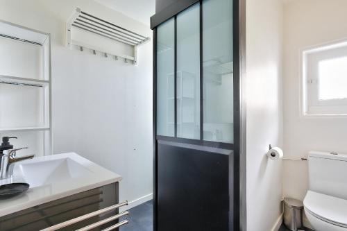 a bathroom with a black shower door and a sink at Charmante maison bretonne pour 6, a Saint-Suliac in Saint-Suliac