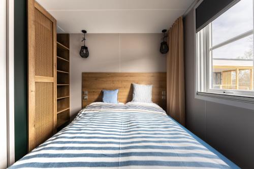 ein großes Bett in einem Zimmer mit Fenster in der Unterkunft Boje 67 in Scharbeutz