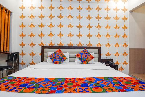 a bedroom with a bed with a colorful comforter at FabExpress Shree Karuna in Transport Nagar