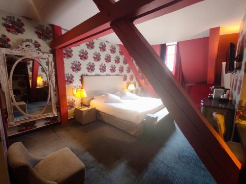 a bedroom with a bed and a staircase with a mirror at Hôtel de Paris in Besançon