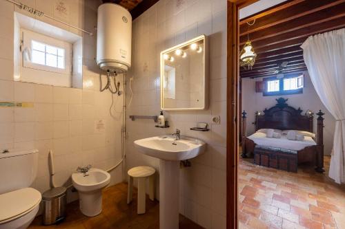 1 cama y baño con lavabo y aseo. en Villa Puig Blanc, en Montecristo