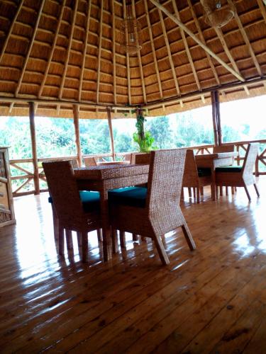 a dining table and chairs in a room with a view at Keije Resort Bunyonyi in Kabale