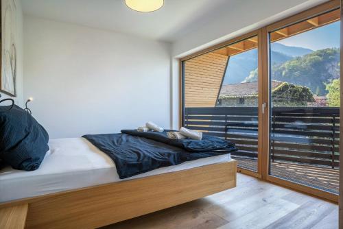 a bedroom with a bed and a large window at Julia's Guesthouse in Ora/Auer