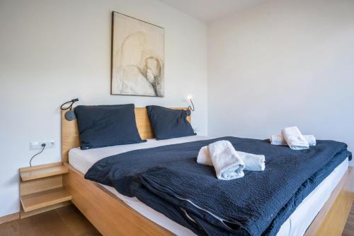 sypialnia z łóżkiem z niebieską pościelą i poduszkami w obiekcie Pension Grasser Apartment w mieście Auer