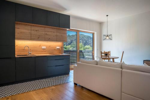a living room with a couch and a kitchen at Julia's Guesthouse in Ora/Auer