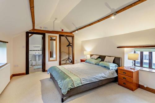 ein Schlafzimmer mit einem großen Bett und einem Fenster in der Unterkunft Beautiful 10 Bed Oak beamed Country House in Tibenham