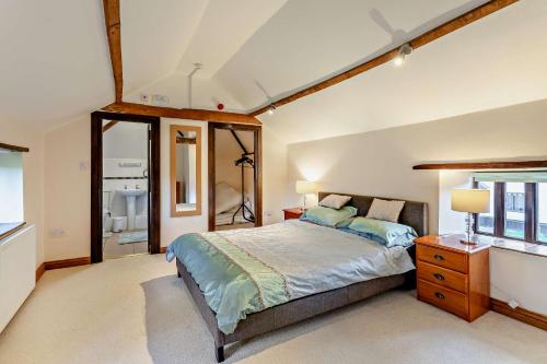 a bedroom with a large bed and a window at Beautiful 10 Bed Oak beamed Country House in Tibenham