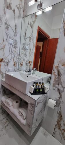 ein Bad mit einem Waschbecken und einem Spiegel in der Unterkunft PREMIUM SUITES in Ofrynio