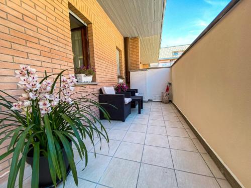 a patio with a couch and flowers on a building at Viterbo Holiday House in Viterbo