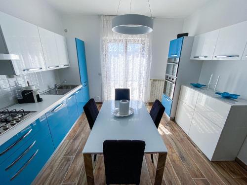a kitchen with blue cabinets and a table with chairs at Viterbo Holiday House in Viterbo