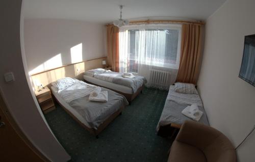 a hotel room with two beds and a window at Ośrodek Wypoczynkowy Diuna Beskidy in Korbielów