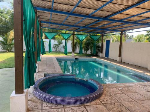 una piscina con pérgola junto a una piscina en Chalet Casa Vacacional Riveras de Chulamar, en Puerto San José