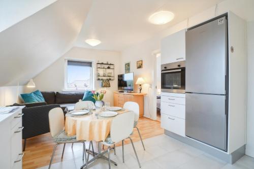 a kitchen and a living room with a table and chairs at Ama Hyg Atelier Copenhagen-LOVELY TOP FLOOR Apart -NEAR AIRPORT-METRO AND THE BEACH in Copenhagen
