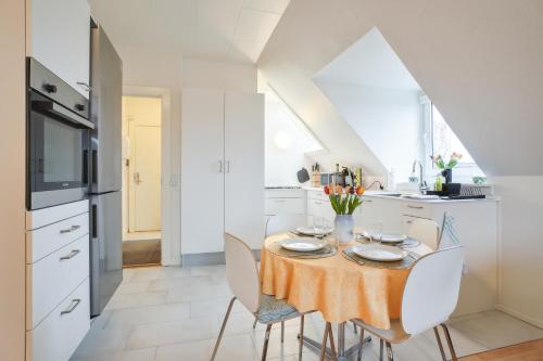 a dining room with a table and chairs in a kitchen at LOVELY TOP FLOOR Apart COPENHAGEN NEAR AIRPORT, METRO AND THE BEACH in Copenhagen