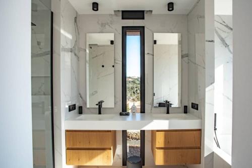 une salle de bain avec deux lavabos et deux miroirs dans l'établissement VILLA ISULA BELLA, à Porto-Vecchio