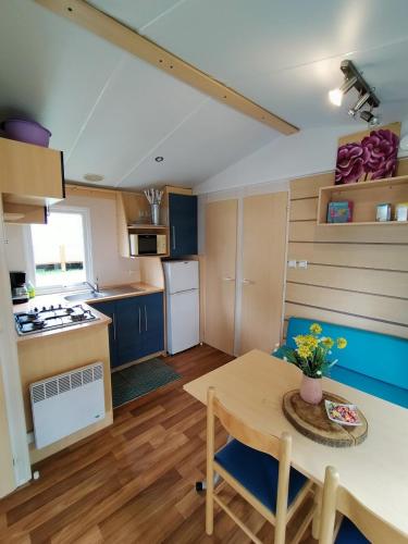 a kitchen with a table and a kitchen with blue cabinets at Mobilhome in Boofzheim