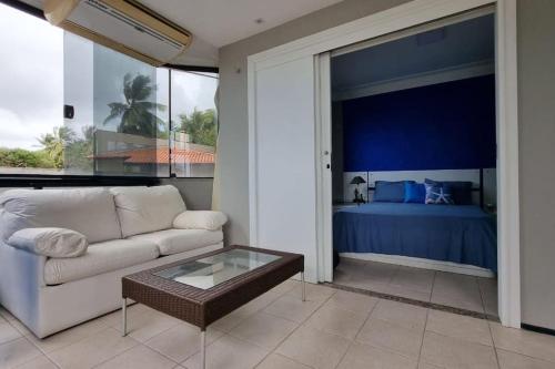 een woonkamer met een bank en een bed bij Apartamento pé na areia in São Luís