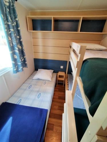a bedroom with two bunk beds and a chair at Mobilhome in Boofzheim