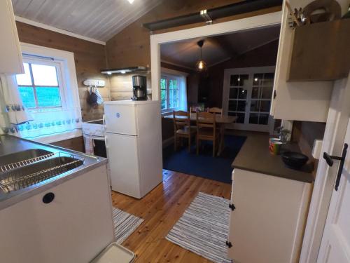 una cucina con frigorifero e una sala da pranzo di Gaulabua - cozy cabin by the river Gaula a Haltdalen