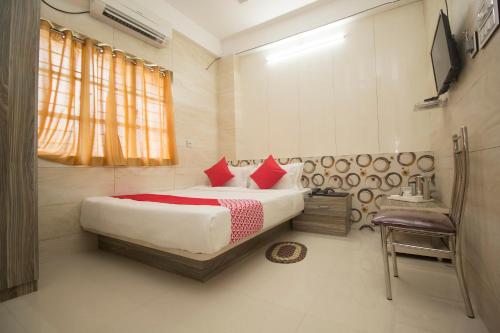 a bedroom with a large bed with red pillows at Super Capital O Priyanshu in Siliguri