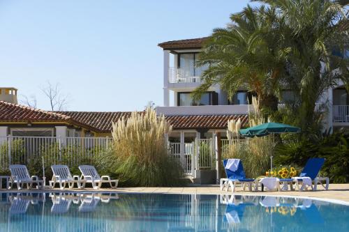 a hotel with chairs and a swimming pool at SOWELL RESIDENCES Les Perles du Golfe de Saint-Tropez in Grimaud
