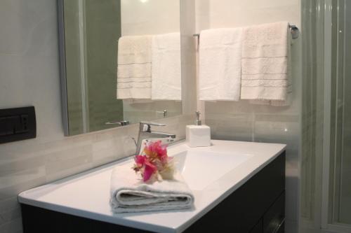 a bathroom with a sink with towels and a mirror at Angoletto Young B&B in Avellino