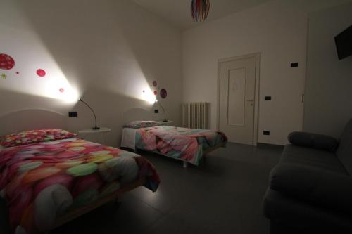 a bedroom with two beds and a couch and a door at Angoletto Young B&B in Avellino