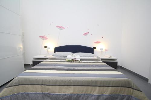 una camera da letto con un grande letto con due tavoli di Angoletto Young B&B ad Avellino