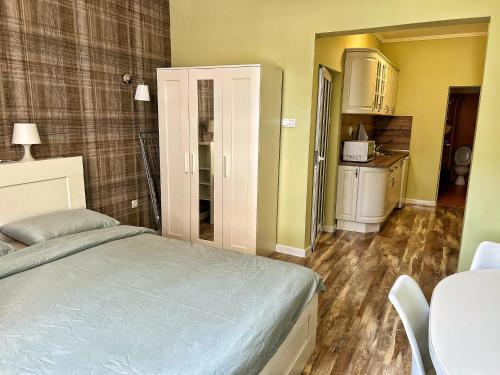 a bedroom with a bed and a table and a kitchen at Студио Top City Center in Plovdiv
