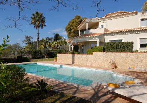 a villa with a swimming pool in front of a house at Casa La Vendola in Estômbar