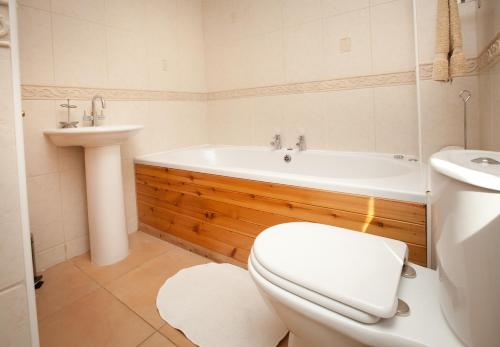 a bathroom with a tub and a toilet and a sink at The Byre, Back Borland Holday Cottages in Stirling