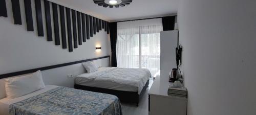 a hotel room with two beds and a window at Kaptanhan Pansiyon in Kazıklı