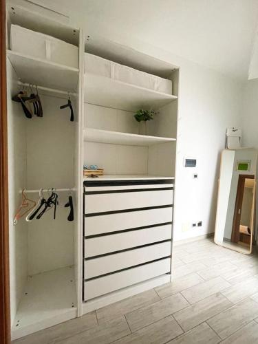 a closet with white shelves and a white refrigerator at Dimora Anna in Termoli