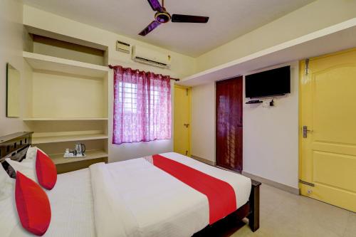 a hotel room with a bed and a tv at Senthamizh Residency in Chennai