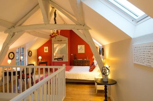 um quarto com paredes cor de laranja e uma cama num quarto em La Folie Saint Julien em Saint-Julien-de-Chédon