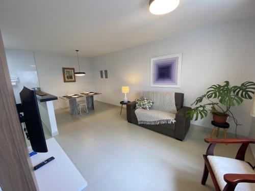 een woonkamer met een bank en een tafel bij Vila das Dunas - aluguel de temporada in Cabo Frio