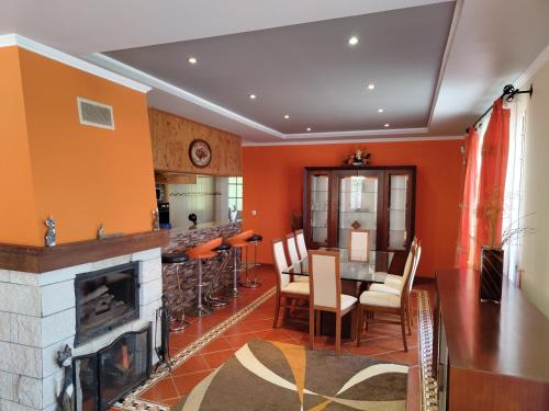 a living room with a fireplace and a table and chairs at Casa Rosa - Vereda da Ilha in Santana