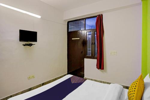 a room with a bed and a window and a television at SPOT ON Raj Hotel Vip Near Worlds Of Wonder in Kalkaji Devi