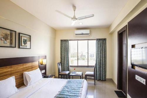 a hotel room with a bed and a window at Reeva Regency in Shirdi
